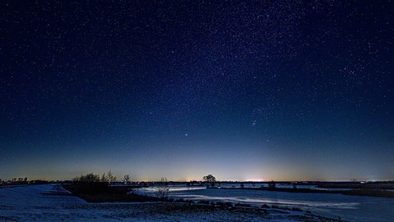 Über einer verschneiten Landschaft leuchtet der Sternenhimmel. © NDR Foto: Lorenz Wodzinski
