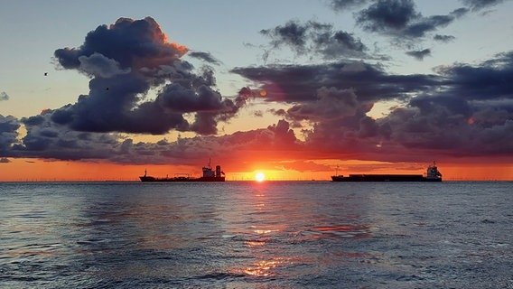 Auf der Nordsee fahren zwei Schiffe in der untergehenden Sonne. © NDR Foto: Everilde Funke