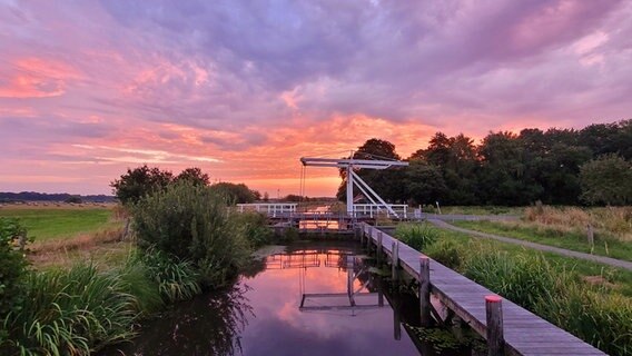 Eine Brücke am Kanal in Mittegroßefehn bei Sonnenaufgang. © NDR Foto: Marion Holtz