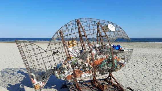 Ein Fisch aus Draht steht am Strand von Norderney um Müll hinein zuwerfen. © NDR Foto: Peter Dettmers