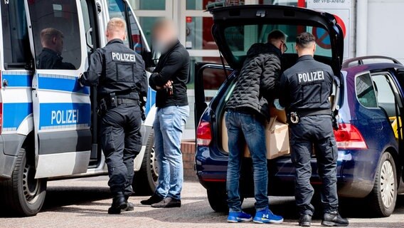 Wiesmoor: Ermittlungsbeamte der Polizei verstauen vor einer Sporthalle mehrere Umzugskartons in Einsatzfahrzeugen. © dpa-Bildfunk | Hauke-Christian Dittrich/dpa Foto: Hauke-Christian Dittrich