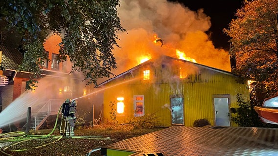 Feuerwehrleute vor einer brennenden Lagerhalle in Wilhelmshaven © Feuerwehr Wilhelmshaven 