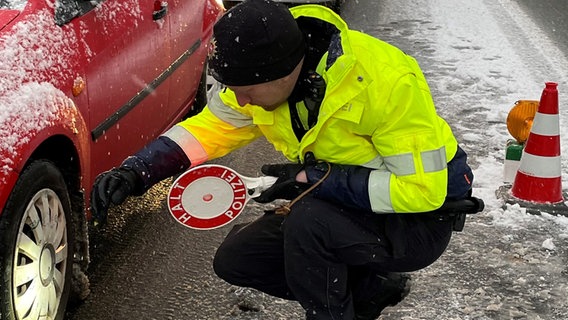 Ein Polizist kontrolliert die Reifen an einem Pkw. © Polizeiinspektion Wilhelmshaven/Friesland 