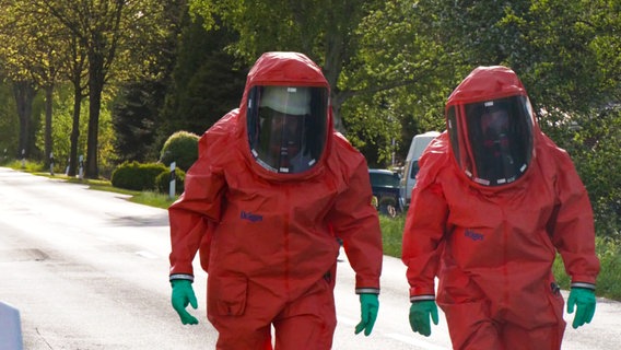 Einsatzkräfte der Feuerwehr in Schutzanzügen bei einem Säureeinsatz in Willmsfeld (Landkreis Wittmund). © NonstopNews 