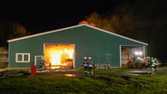 Feuerwehrleute löschen den Brand eines landwirtschaftlichen Gebäudes in Wirdum. © NonstopNews 