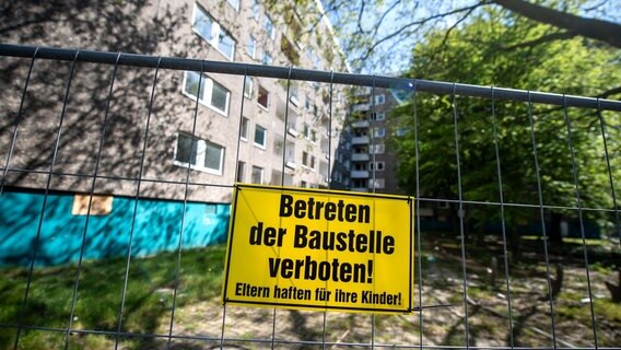 Ein Schild mit der Aufschrift: "Betreten der Baustelle verboten" hängt an einem Bauzaun vor einem Wohnblock. © dpa-Bildfunk Foto: Sina Schuldt