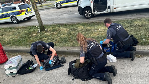 Zollbeamte durchsuchen an einer Autobahnraststätte Reisetaschen und Rucksäcke. © Polizeiinspektion Rotenburg 