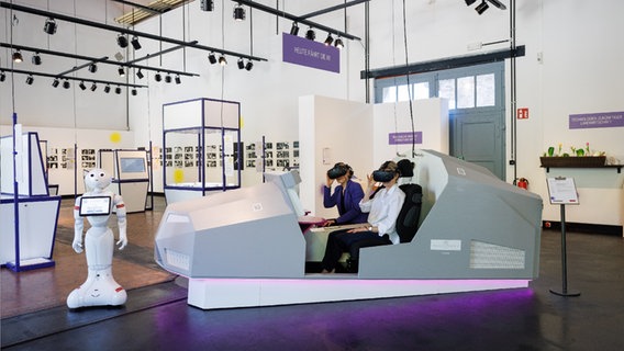 Zwei Menschen sitzen im Modell eines futuristischen Autos. © Museum Industriekultur Osnabrück 