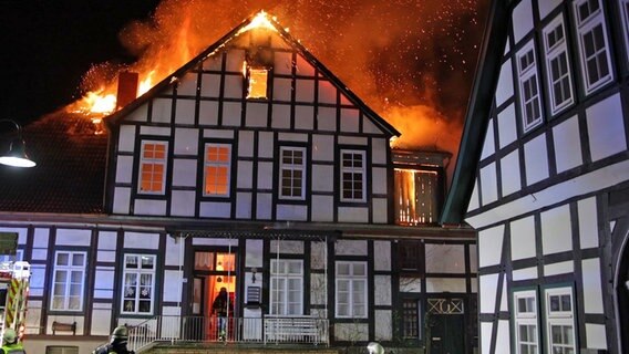 Aus einem Fachwerkhaus lodern Flammen.  Foto: Nord-West-Media TV/dpa