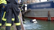 Taucher untersuchen den Rumpf eines leckgeschlagenen Frachtschiffes im Mittellandkanal in Bad Essen. © Nord-West-Media TV 