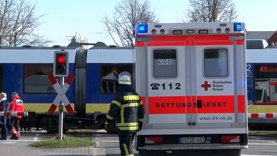 Rettungswagen und Einsatzkräfte stehen an einem Bahnübergang © Nord-West-Media TV 