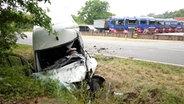 Ein Fahrzeug ist nach einem Unfall in Barver (Landkreis Diepholz) stark beschädigt. Im Hintergrund stehen Lkws. © NWM TV 