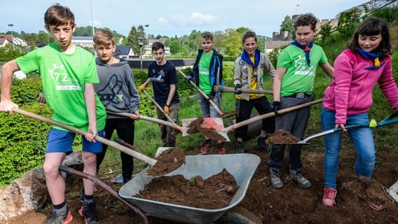 Kinder schaufeln Erde in eine Schubkarre © BDKJ Bundesstelle Foto: Henning Schoon