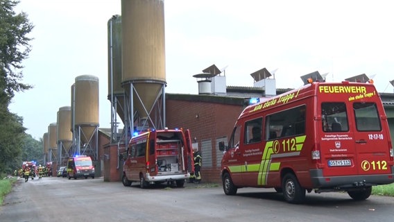Feuerwehrfahrzeuge stehen auf dem Gelände eines Geflügelzuchtbetriebs. © Nord-West-Media TV 