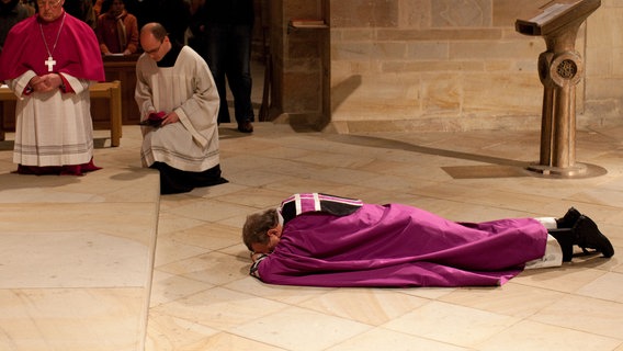 Bischof Franz-Josef Bode liegt im Dom von Osnabrück vor dem Altar auf dem Boden. © picture alliance / dpa | Friso Gentsch Foto: Friso Gentsch