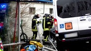 Einsatzkräfte der Feuerwehr stehen nach einem Unfall in Bissendorf neben einem Kleinbus. © Nord-West-Media TV Foto: Nord-West-Media TV
