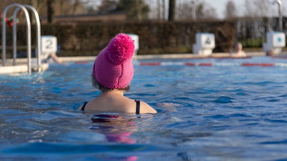Eine Frau schwimmt mit einer Mütze auf dem Kopf im Freibad in Bohmte. © dpa-bildfunk Foto: Friso Gentsch