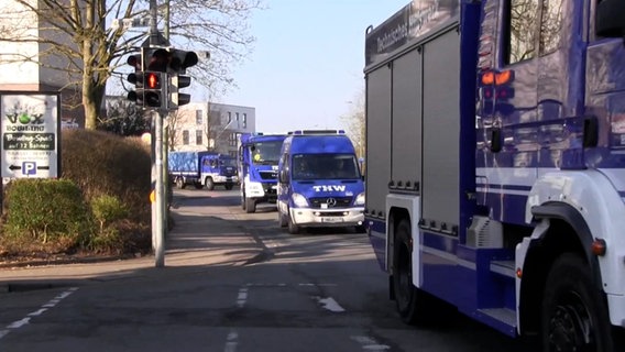 Nach dem Verdacht einer Weltkriegsbombe in Osnabrück fahren mehrere Einsatzfahrzeuge des THW durch eine Straße. © Nord-West-Mediat TV 
