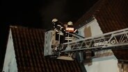 Einsatzkräfte der Feuerwehr löschen einen Brand an einem Wohnhaus. © Nord-West-Media TV 