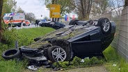 Ein Auto liegt nach einem Unfall auf dem Dach. © Nord-West-Media TV/dpa 