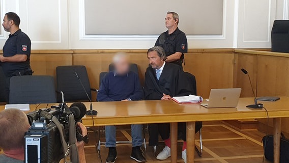 Ein Angeklagter sitzt neben seinem Verteidiger in einem Gerichtssaal. © NDR Foto: Susanne Schäfer