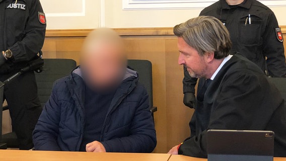 Ein Angeklagter sitzt neben seinem Verteidiger in einem Gerichtssaal. © NDR Foto: Karoline Kempe