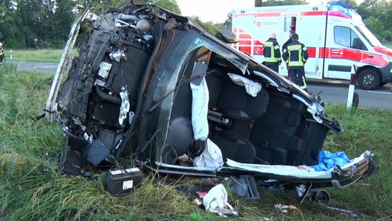 Ein Auto liegt auf der Seite nach einem Unfall in Bramsche, im Hintergund Rettungkräfte. © Nord-West-Media TV 