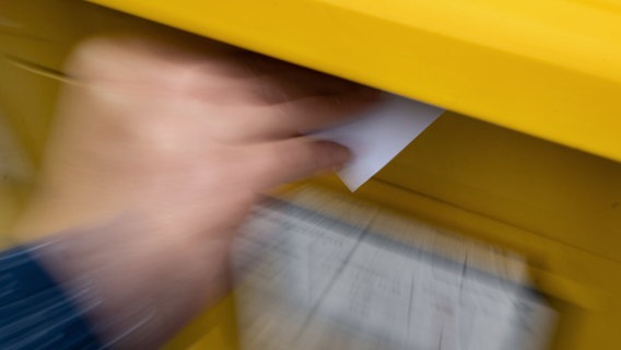 Eine Frau wirft einen Standardbrief in einen Briefkasten. © picture alliance/dpa Foto: Marijan Murat