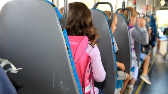 Kinder sitzen mit ihrem Ranzen in einem Schulbus. © picture alliance/dpa Foto: Peter Gercke