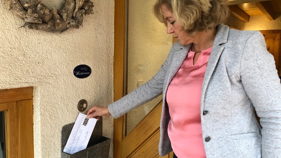 CDU-Abgeordnete Eva-Maria Westermann nimmt einen Brief aus einem Briefkasten. © NDR Foto: Göran Theo Ladewig