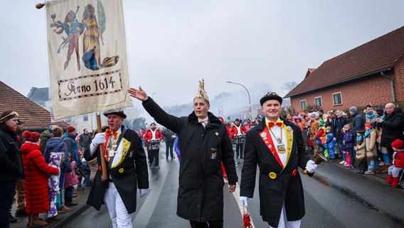 Der Elferrat des Dammer Carnevals trägt beim Straßenkarnevalsumzug durch den Ort die Fahne mit dem Gründungsjahr 1614 der Dammer Carnevalsgesellschaft. © dpa Foto: Focke Strangmann