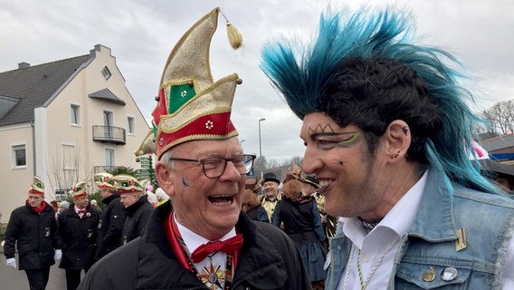 Beim Dammer Carneval ist ein Mann mit Karnevalsschmuck und ein Mann verkleidet als Punk zu sehen. © NDR Foto: Thomas Schwierzi