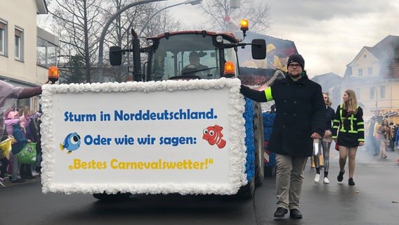 Auf einem Trekker beim Fastnachtsumzug des Dammer Carnevals steht "Sturm in Norddeutschland. der wie wir sagen: Bestes Carnevalswetter!" © NDR Foto: Daniel Sprehe