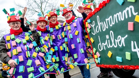 Mit Schwämmen dekorierte Männer stehen neben einem Schild mit der Aufschrift "Schwamm drüber" beim Fastnachtsumzug des Dammer Carnevals. © dpa - Bildfunk Foto: Hauke-Christian Dittrich