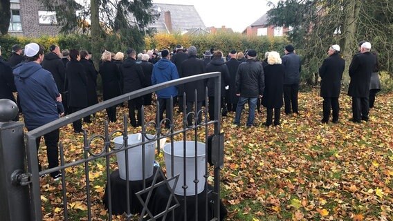 Trauergäste stehen um das Grab der verstorbenen Erna de Vries. © NDR Foto: Hedwig Ahrens