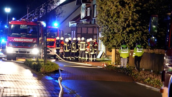 Einsatzkräfte der Feuerwehr vor einem Wohnhaus in Drebber. Auf dem Gelände hat es zum zweiten Mal gebrannt. © NWM TV 