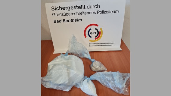 Sichergestellte Drogen auf einem Tisch, auf einem Schild steht "Sichergestellt durch Grenzüberschreitendes Polizeiteam Bad Bentheim". © Bundespolizei 
