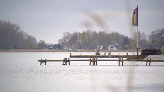 Ein Holzsteg führt auf einen See. © NDR 