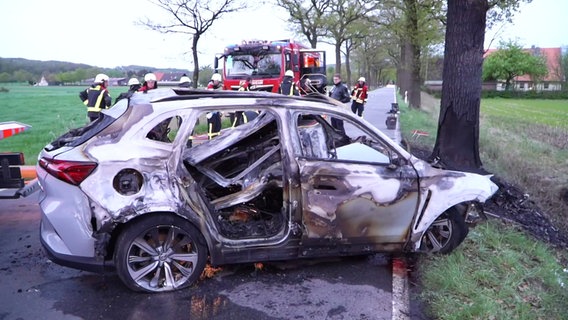Ein ausgebranntes Elektroauto steht nach einem Unfall in Bissendorf auf einer Straße. © Nord-West-Media TV 