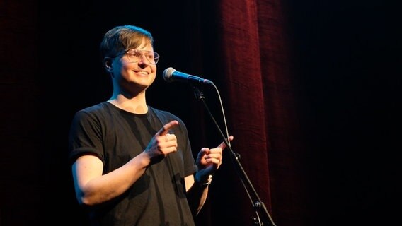 Der Poetry Slammer Florian Wintels steht auf einer Bühne. © Morgaine Prinz Foto: Morgaine Prinz