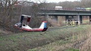 Ein Ultraleichtflugzeug liegt nach einem Absturz neben einer Autobahn. © Nord-West-Media TV 