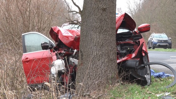 Ein roter Kleinwagen steht mit eingedrückter Front nach einem Unfall bei Geeste an einem Baum. © Nord-West-Media TV 