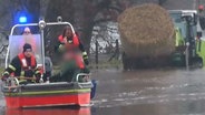 Die Feuerwehr rettet in Geeste (Landkreis Emsland) mit einem Boot einen Mann und einen Hund aus einem Trecker. © Nord-West-Media TV 