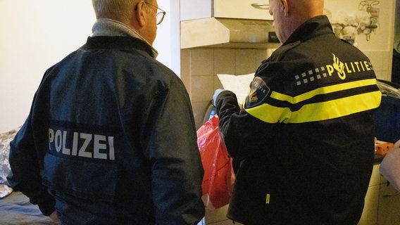 Ein deutscher und ein niederländischer Polizist sichten Beweise bei einer Durchsuchung. © Polizeidirektion Osnabrück 
