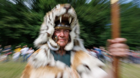 Ein als Römer verkleideter Schauspieler trägt ein Tigerkostüm bei einer Vorführung. © dpa Foto: Friso Gentsch