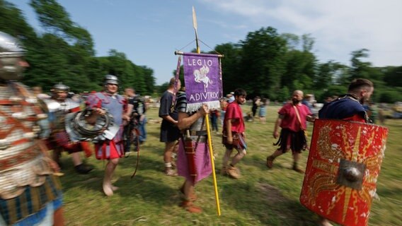 Als Römer verkleidete Schauspieler machen eine Vorführung bei einem Schaukampf. © dpa Foto: Friso Gentsch