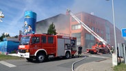 Feuerwehrfahrzeuge vor einer brennenden Halle in Gesmold © Nord-West-Media TV 