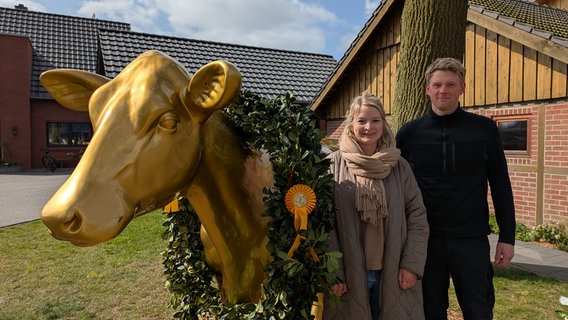 Auf dem Milchhof in Meppen steht neben der Familie Suhr eine lebensgroße goldene Kuh. © NDR Foto: Anke Hoffmann