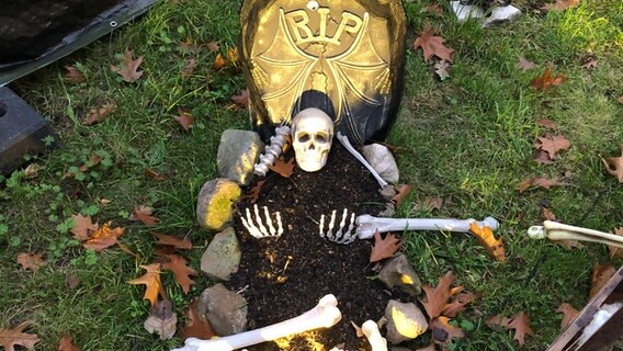 Ein Skelett liegt auf einem Grab. © NDR Foto: Wagma Hayatie