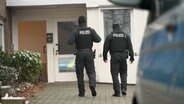 Beamte der Polizei gehen für eine Durchsuchung in ein Haus. © TV7News 